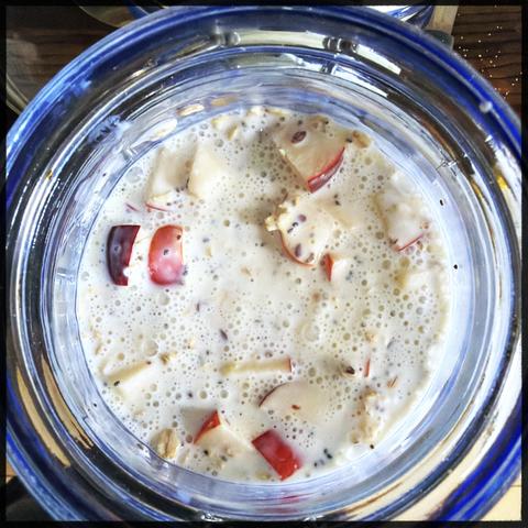 A jar with overnight oats. One can spit chia seeds and apple slices among the yoghurt and oats.