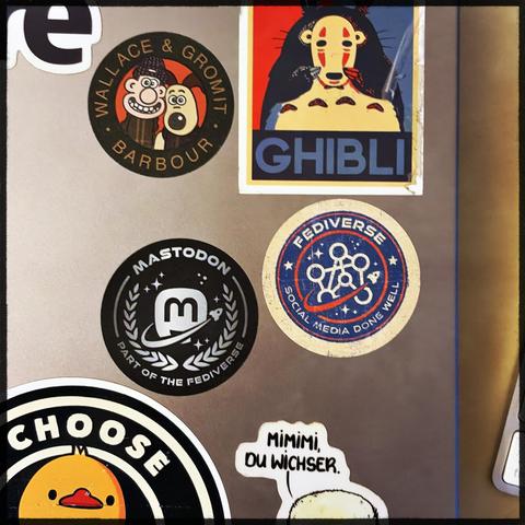 A laptop with several stickers on it. Featuring Fediverse stickers prominently 